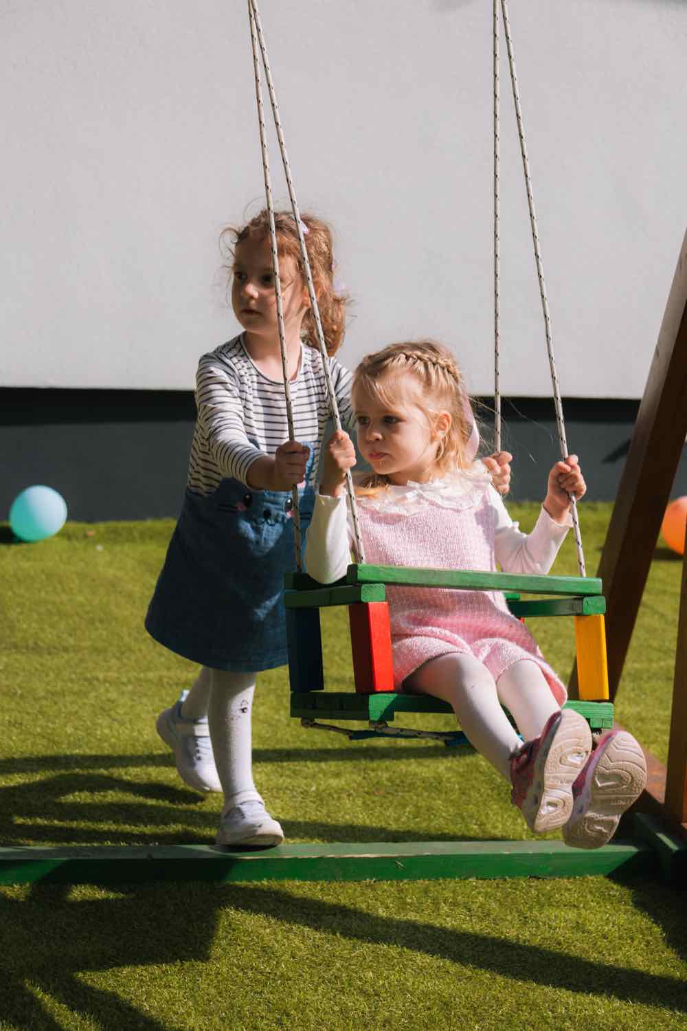 Deca na ljuljaškama u dvorištu igraonice