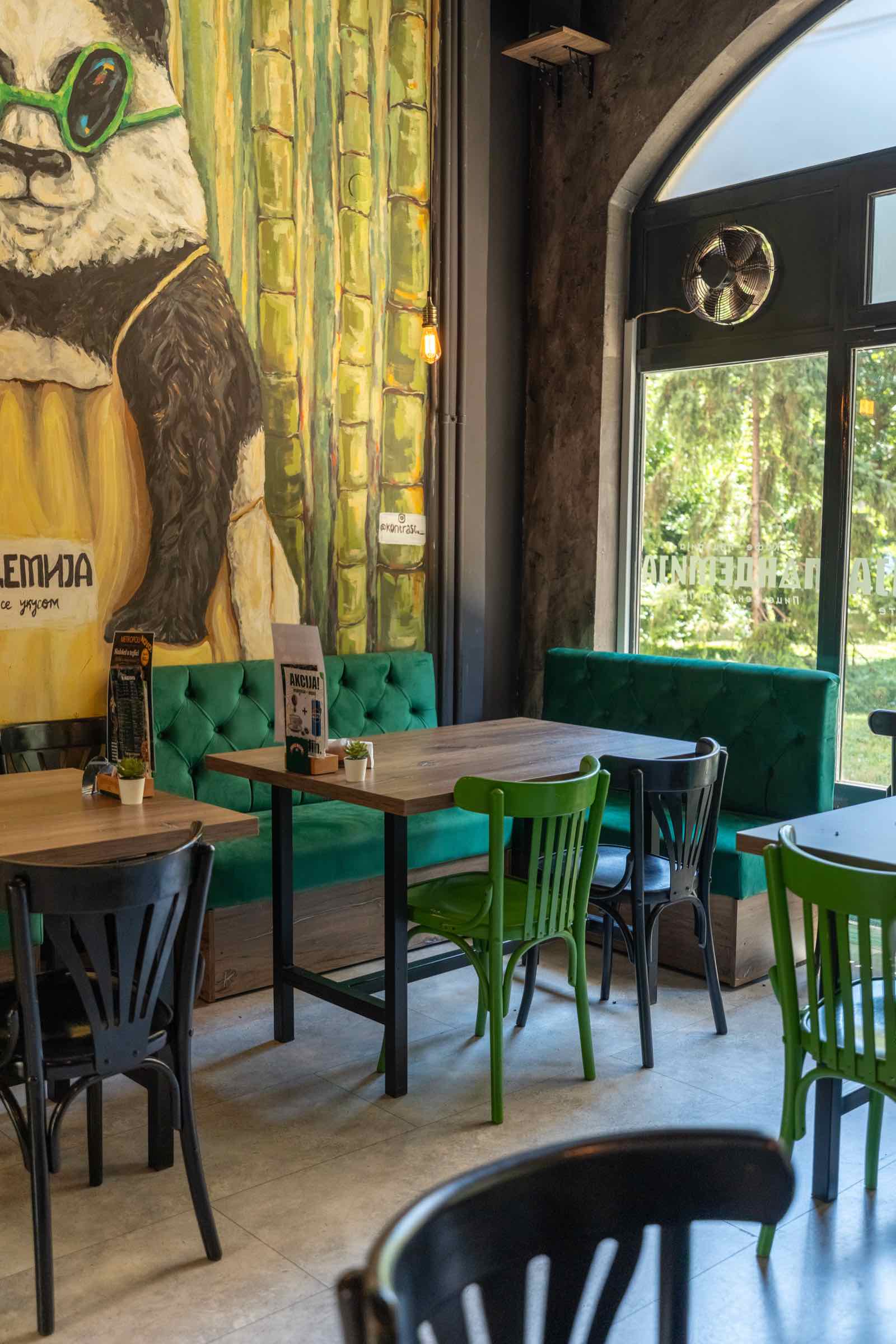 Sala Pandemije sa zelenim separeima i muralom pande